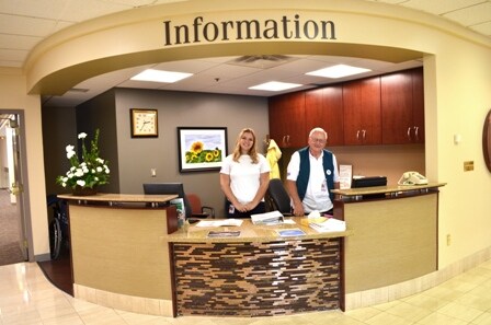 Chloe Hays, a Free State High School senior who is a Health Careers Pathways intern, and Paul Flower, information desk volunteer, volunteer at Lawrence Memorial Hospital.