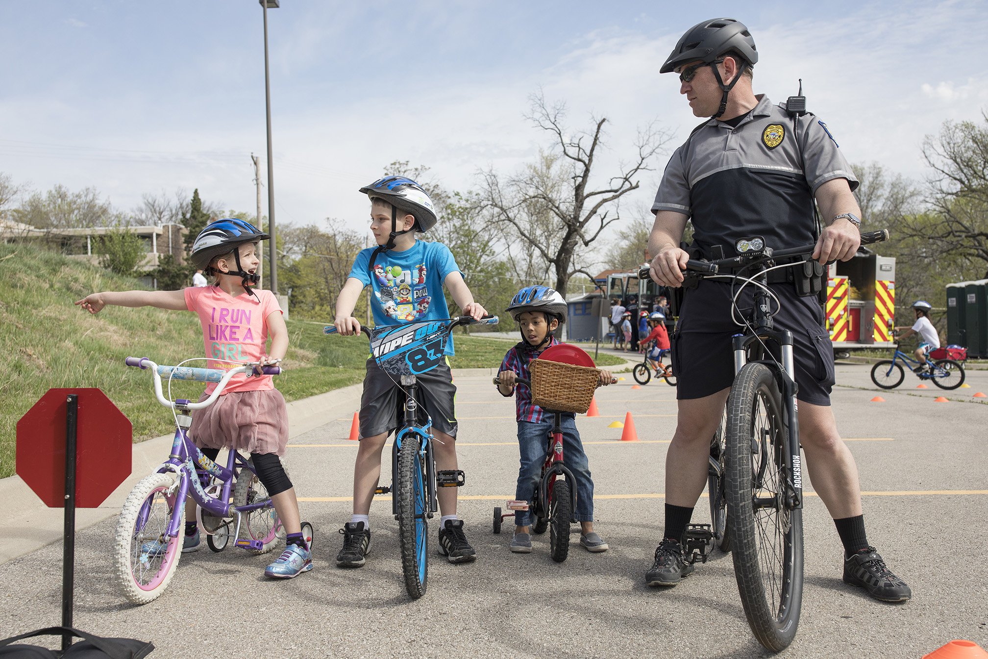 Three children and police officer on bicycles