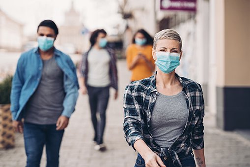 Four people wearing masks downtown