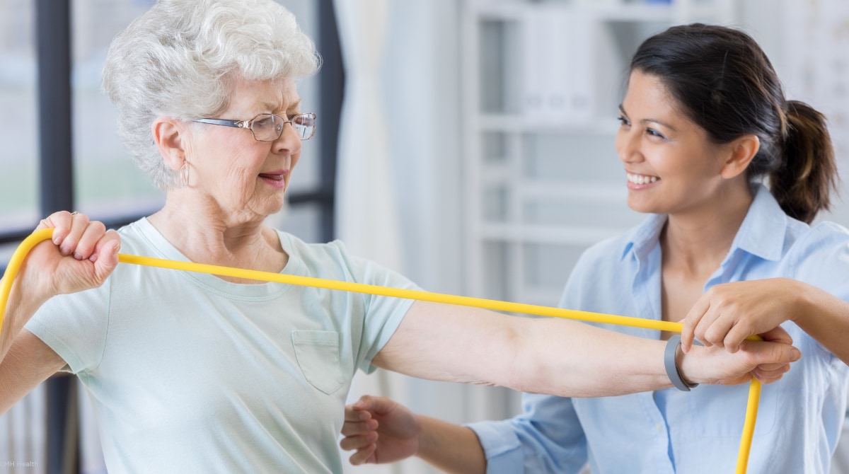 Image of a senior woman working with a physical therapist